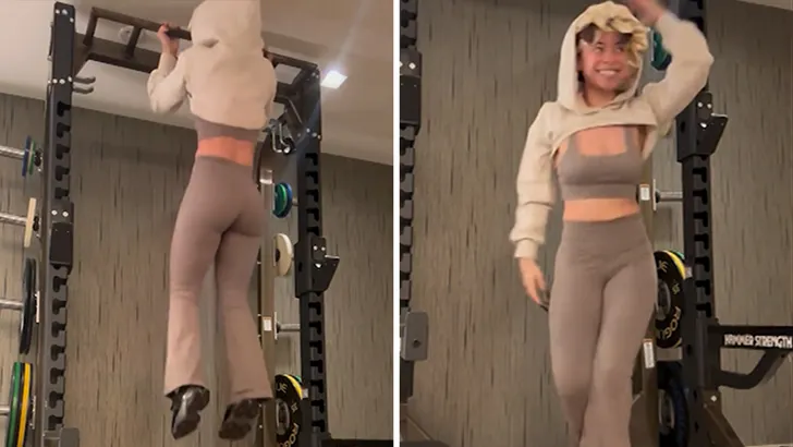 Ice Spice doing pull ups in the gym wearing grey gym suit and white hoodie